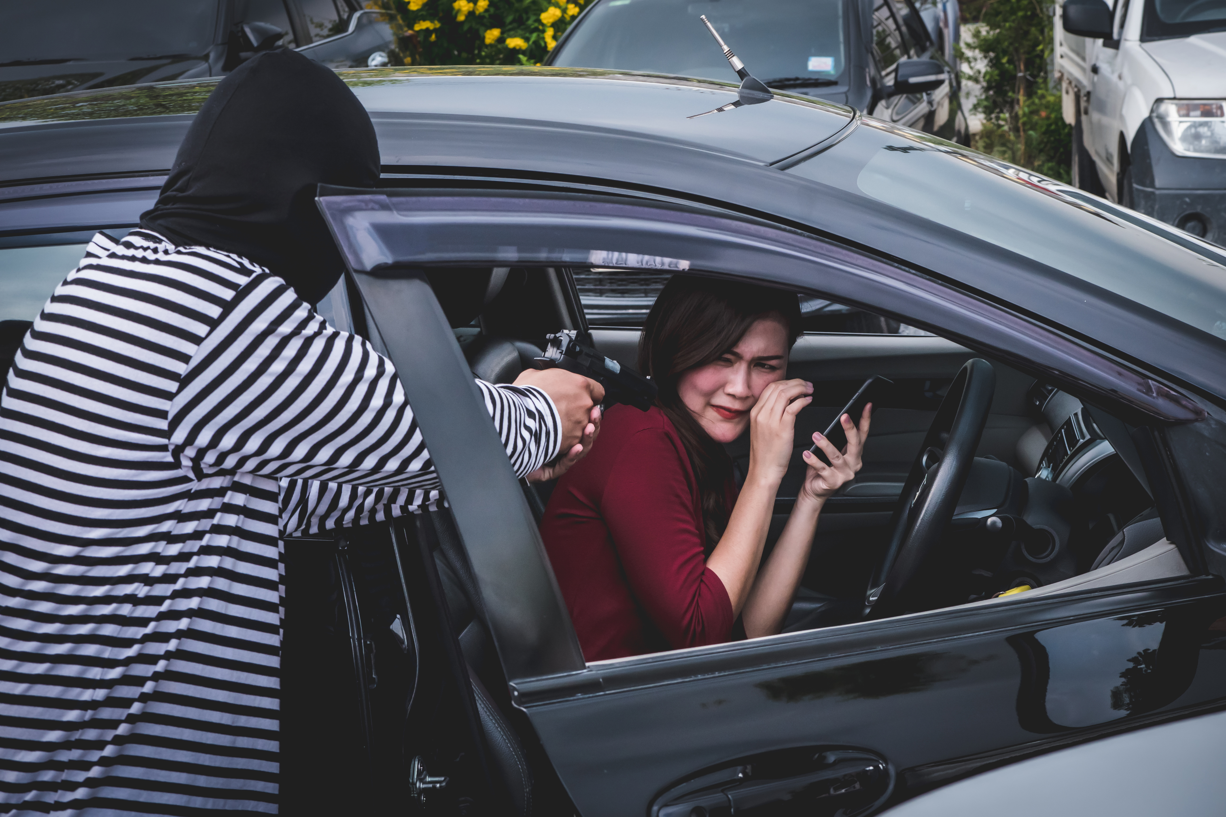 robber-pointing-a-gun-to-scare-young-woman-and-try